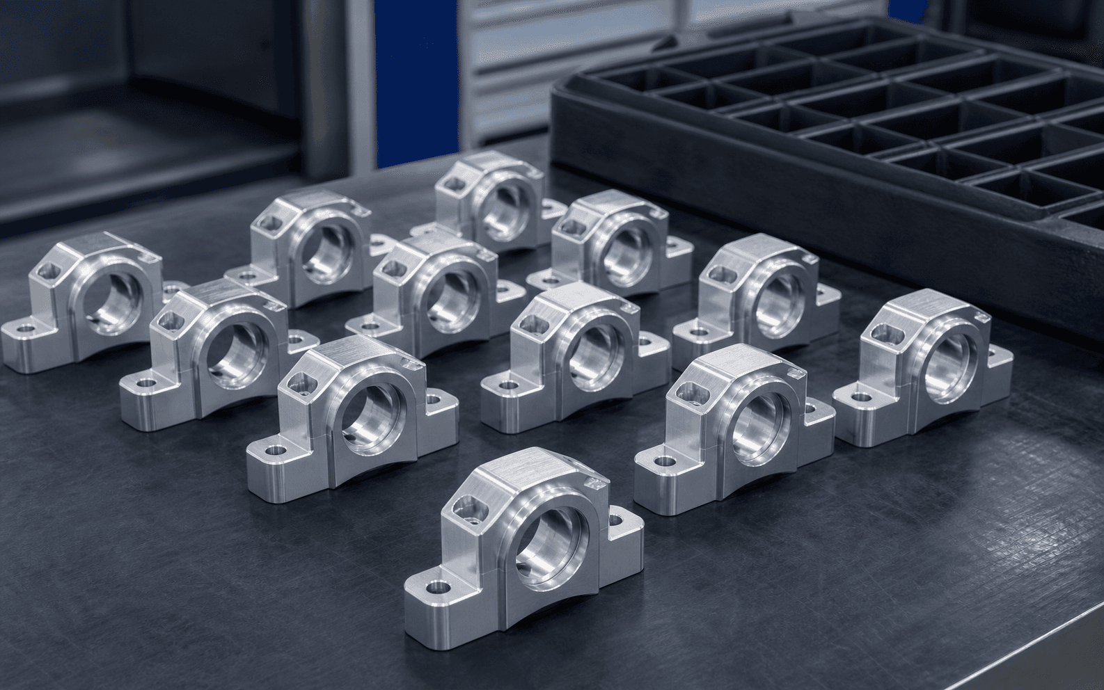 Multiple identical machined aluminium components arranged professionally for repeat production delivery